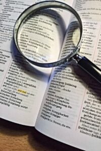 a book, duden, magnifying glass and legal notice