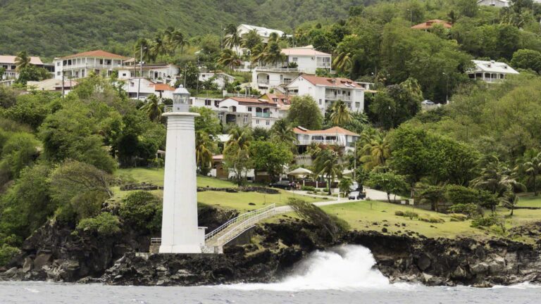 Waves coming around the corner in the straights between Guadeloupe and the Iles des Saintes break at the lighthouse shore.