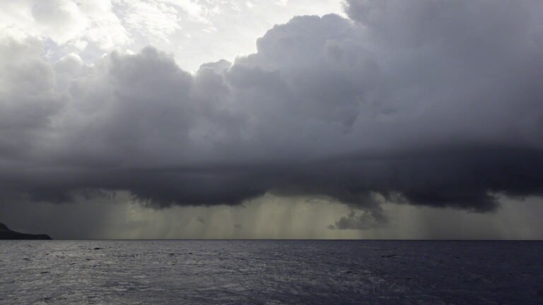 On passage from Falmouth Harbour in Antigua to Guadeloupe these dark clouds and rain had me put in double reefs in both sails