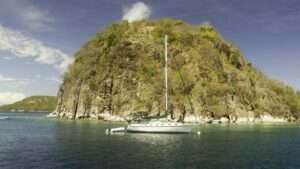 The small sugarloaf mountain called Pain de Sucre in the Saintes off Guadeloupe with yacht "Reprieve"