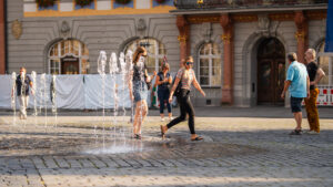 Two girls walking by a city water feature